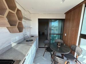 eine Küche mit Tisch und Stühlen und einer Spüle in der Unterkunft Apartamento 40m da praia Maragogi vista mar in Maragogi