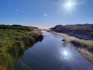 a view of a river with the sun in the sky at Henne Station, Midtiby B & B in Henne +5 photos