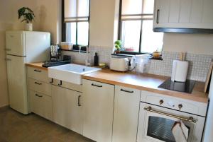 a kitchen with a white refrigerator and a sink at Къща за гости Белора in Dryanovo