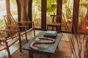 una mesa de madera con un libro y dos sillas en Pousada Topázio by Amana, en Fernando de Noronha 24 fotos más