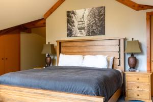 a bedroom with a wooden bed and two lamps at The Alders Chalet by Fernie Central Reservations in Fernie