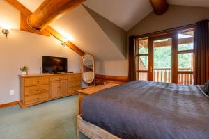 a bedroom with a large bed and a television at The Alders Chalet by Fernie Central Reservations in Fernie