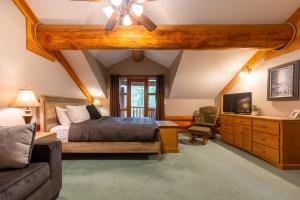 a bedroom with a bed and a couch and a tv at The Alders Chalet by Fernie Central Reservations in Fernie +36 photos