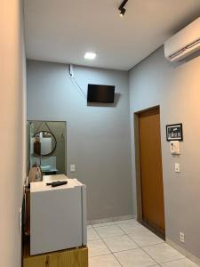 Ein Zimmer mit einer Theke und einem Fernseher an der Wand in der Unterkunft Flat MDC 02 in Iturama + 8 Fotos