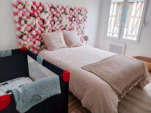 a bedroom with a bed with flowers on the wall at Adresse cachée in Chalons en Champagne