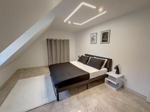 ロスハイムにあるLes suites du lionのベッドルーム1室(屋根裏に黒と白のベッド1台付) +8枚の写真