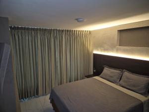 a bedroom with a bed and a window with curtains at Laureles del parque loft in Barranquilla