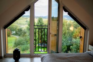 a bedroom with a large window with a view at StyLove Domki 1 in Kluszkowce +32 photos