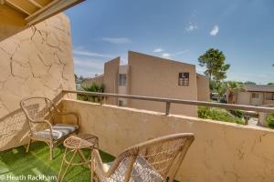 eine Terrasse mit Stühlen und Tischen auf dem Balkon in der Unterkunft 3bd Condo Near Old Town King Bed in Scottsdale
