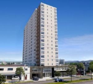 a tall white building in a city at Departamento Centro Chillan - Parking -Vista in Chillán