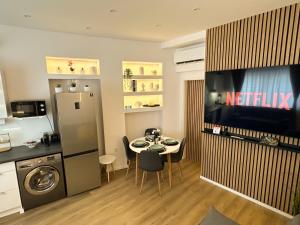 a kitchen with a table and a tv in a room at VIBE S33 Apartman Modern & Prémium in Székesfehérvár