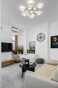 a living room with a couch and a chandelier at Joy Social Apartment in Bucharest