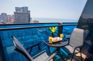 a table with a bowl of food on a balcony at Orbi City Superhost in Batumi