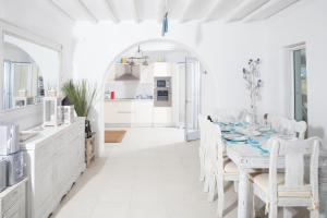 3 Bedroom Cycladic Villa Lia في كالافاتيس: غرفة طعام بيضاء مع طاولة وكراسي