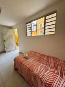 a bedroom with a bed with a cat laying on it at Suíte charmosa com banheiro privativo, bairro tranquilo e arborizado, próximo ao metrô Ana Rosa e Avenida Paulista! in Sao Paulo