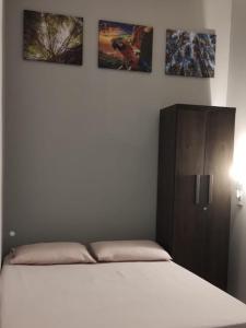 ein Bett in einem Schlafzimmer mit drei Bildern an der Wand in der Unterkunft Flat MDC 02 in Iturama
