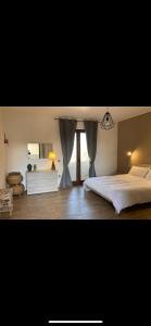 a bedroom with a large bed and a window at Le bouganville in Maracalagonis +1 photo