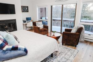 a living room with a bed and chairs and a fireplace at NEWLY REMODELED FOUR BEDROOM All SEASON CONDO W MOUNTAIN VIEWS in East Jewett