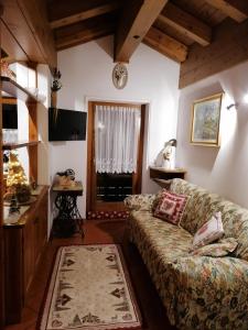 a living room with a couch and a window at Stella Alpina Holiday Home in Auronzo di Cadore