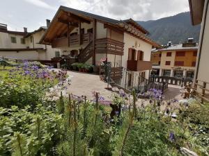 a garden with flowers in front of a house at Stella Alpina Holiday Home in Auronzo di Cadore