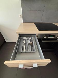 a drawer in a kitchen with utensils in it at Appartement spacieux centre Huy in Huy +5 photos