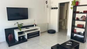 ein Wohnzimmer mit einem Flachbildfernseher an der Wand in der Unterkunft Departamento Libertad in Villa Carlos Paz + 2 Fotos