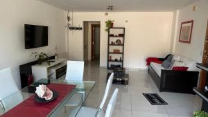 ein Wohnzimmer mit einem Glastisch und einer Couch in der Unterkunft Departamento Libertad in Villa Carlos Paz