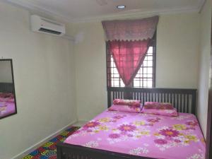 a bedroom with a pink bed and a window at Z&R HOMESTAY in Kota Bharu