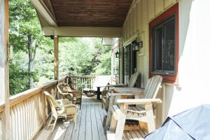 a porch with chairs and a table and a bench at Eagle Rock in Beech Mountain