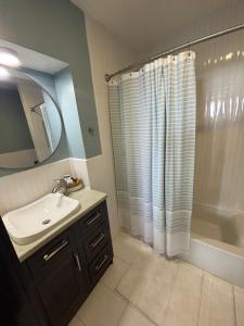 a bathroom with a sink and a shower curtain at 360 Suites, Seaside Luxury, 4 Bedrooms, 3 Bath in Caye Caulker +21 photos