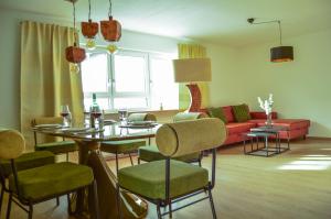 a living room with a table and chairs and a couch at Wellness & Fun am Bodensee - mit Pool, Kino, Tischkicker und Terrasse in Markdorf