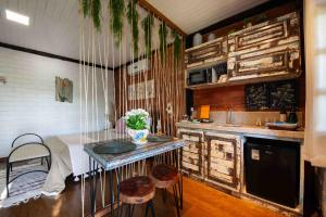 a kitchen with a table and two stools in it at Vale do Lago - Casa de Campo e Eventos in Vila Velha
