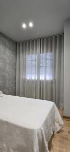 a bedroom with a white bed and a window at Maruja Rural 2 in Sober