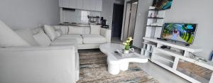a white living room with a white couch and a tv at Chichi homes sabaki residents in Nairobi