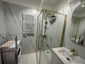un baño con ducha y lavabo en Apartament Moniuszki, en Słupca