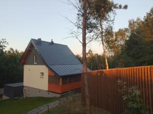 a house with a blue roof and a fence at Domek na zboczu Kistowo z Balią in Sulęczyno