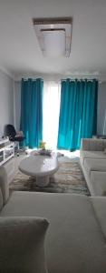 ナイロビにあるChichi homes sabaki residentsのリビングルーム(青いカーテン、白いソファ付) +6枚の写真