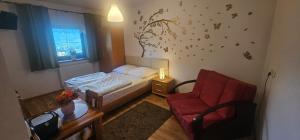 ein kleines Schlafzimmer mit einem Bett und einem Stuhl in der Unterkunft Szepty Lasu in Szklarska Poręba