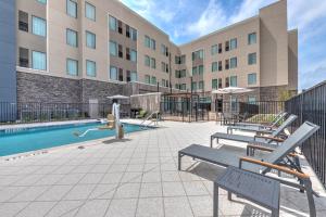 a hotel patio with a swimming pool and benches at Staybridge Suites Port Arthur - by IHG in Port Arthur