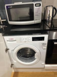 a microwave sitting on a counter next to a washing machine at Room Imperial in London