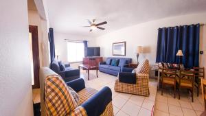a living room with a blue couch and chairs at Pool Home Near Palm Beach Plaza – Sleeps 13 in Saliña Cerca