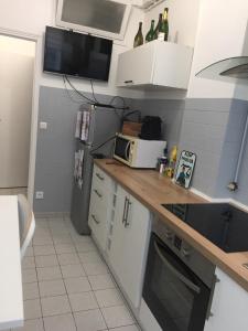 ラ・ガレンヌ・コロンブにあるLe 2piéces parfait pour votre séjour !の小さなキッチン(カウンター、冷蔵庫付) +2枚の写真