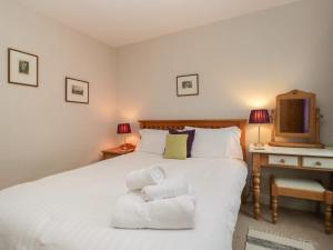 ein Schlafzimmer mit einem weißen Bett mit Handtüchern darauf in der Unterkunft Cloud Cottage in Ambleside