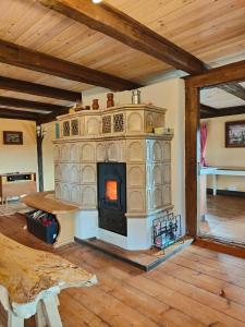 ein Wohnzimmer mit Kamin und Tisch in der Unterkunft Ferienhaus Gut Haselbach im Erzgebirge in Olbernhau