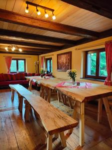 Großes Zimmer mit Holztischen und Bänken in der Unterkunft Ferienhaus Gut Haselbach im Erzgebirge in Olbernhau