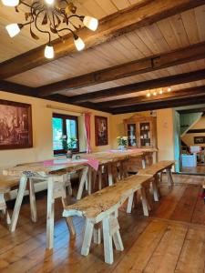 ein großes Esszimmer mit Holztischen und Bänken in der Unterkunft Ferienhaus Gut Haselbach im Erzgebirge in Olbernhau