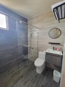 a bathroom with a toilet and a glass shower at Hotel Plaza Mariarca in Azua
