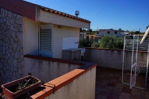 a balcony of a house with a planter on it at Casa del Cedro in Brucoli +3 photos