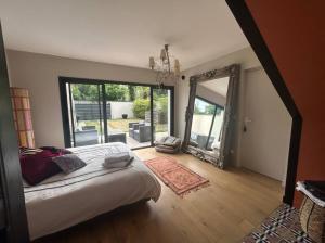 a bedroom with a bed and a large mirror at La suite de Chantepie in LʼIsle-Adam