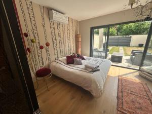 a bedroom with a bed and a large window at La suite de Chantepie in LʼIsle-Adam +8 photos